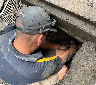 Bell plumber working in a drain pit