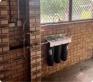 Water filtration system installed on a brick wall